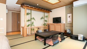 A traditional Japanese-style room with tatami flooring, a low table with cushions, a TV, and a cabinet. - Hotel C&i Koriyama (Koriyama)