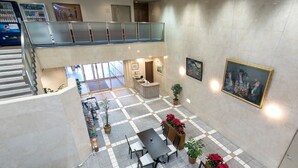 A spacious indoor area with a checkered floor, seating arrangements, and a staircase leading to an upper level. - Hotel C&i Koriyama (Koriyama)