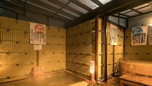A traditional Japanese onsen with wooden benches and a hot spring bath. - Hotel C&i Koriyama (Koriyama)