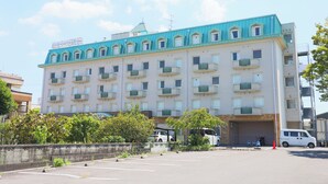 Ein mehrstöckiges Hotel mit blauem Dach und mehreren Balkonen.