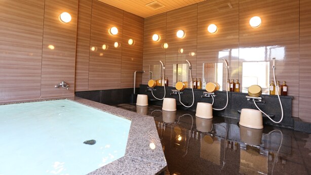 Une salle de bain moderne dotée d’une grande baignoire, de plusieurs lavabos et de miroirs.