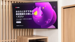 Televisor de pantalla plana en la pared mostrando un video de YouTube con texto en japonés.