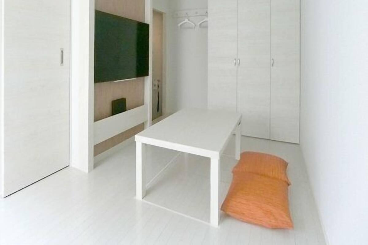 A modern bedroom with a bed, a TV, and a wardrobe.