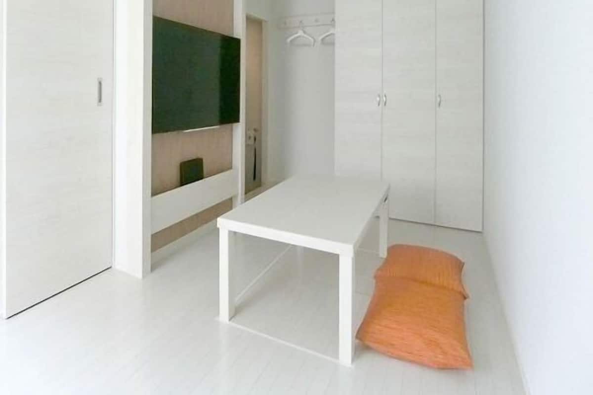 A modern bedroom with a bed, a TV, and a wardrobe.