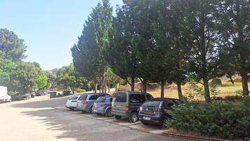 A parking lot with several cars parked along the side of a road.