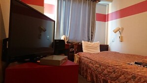 A hotel room with a bed, a TV, a desk, a chair, and a window with curtains. - Annex Hotel Mimatsu (Mito)