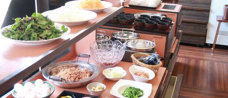A buffet setup with various dishes and condiments.