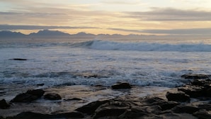 Una costa rocosa con olas rompiendo sobre las rocas.