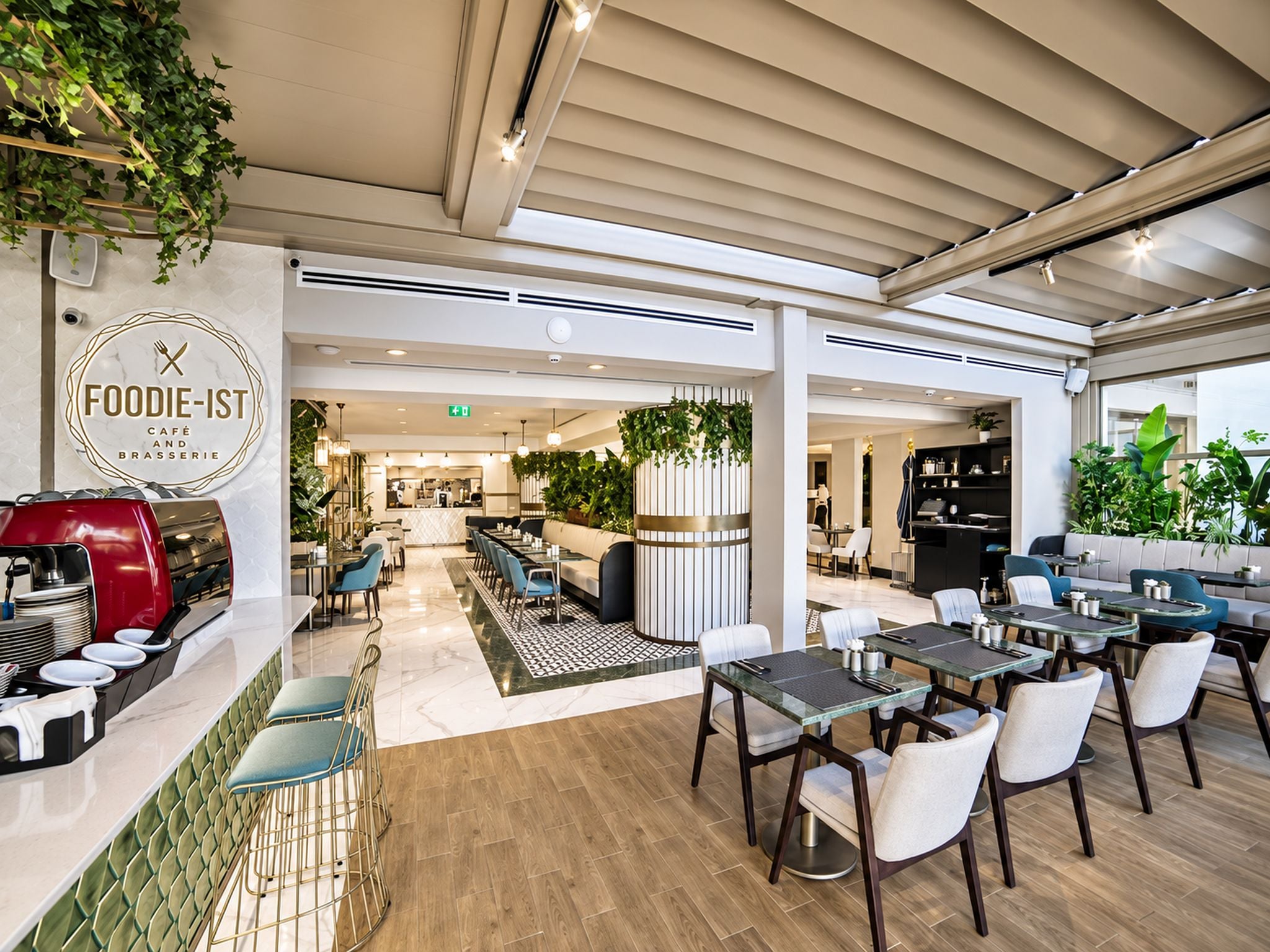 A modern café interior with seating arrangements, a visible menu board, and a kitchen area.