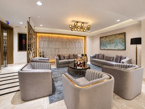 A modern living room with a sofa set, a coffee table, and a chandelier.