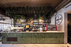 A bar area with a green counter, shelves of bottles, a coffee machine, and a sign that reads 'FOODIE-IST'. - Sura Luxury Milion & Spa (Istanbul)