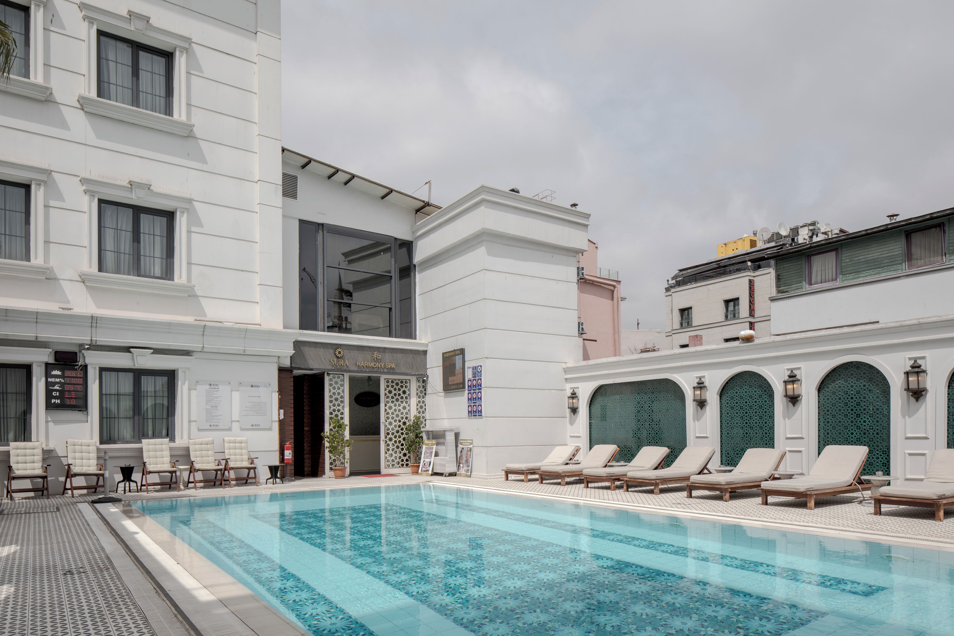 A hotel with a swimming pool, lounge chairs, and a spa entrance.