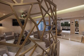 A modern interior with a geometric wooden partition, plush seating, and ambient lighting. - Sura Luxury Milion & Spa (Istanbul)