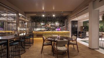 A restaurant with a bar area, wooden flooring, and a view of the street.