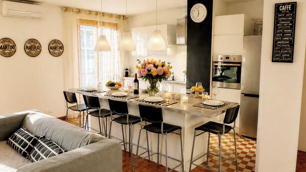 A modern kitchen with a central island, bar stools, a clock, and a menu board. - 4(*) Standing flat, 3 bedrooms, private parking with AC near Panier Vieux-Port (Marseille)