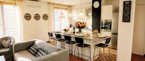A modern kitchen with a central island, bar stools, a clock, and a menu board. - 4(*) Standing flat, 3 bedrooms, private parking with AC near Panier Vieux-Port (Marseille)