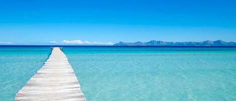 Ranta lähistöllä, aurinkotuoleja, rantapyyhkeitä