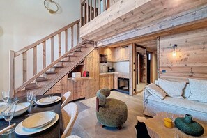 A spacious living area with a wooden staircase, a kitchen, and a sofa. - 200m from resort center, 3rd floor, view ski slopes, balcony, tv, ski locker, 48m² (Saint-Martin-de-Belleville)