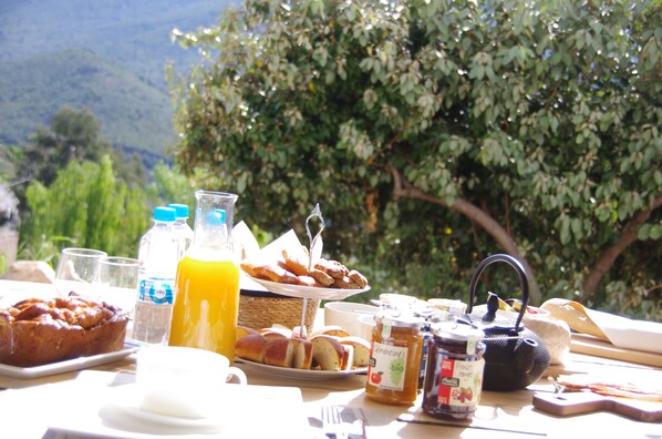 A breakfast table with various food items, a teapot, and a glass of orange juice. - Casa I&B (Peri)