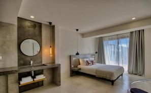 Relax in a serene space with a large bed, round mirror, and storage bench.