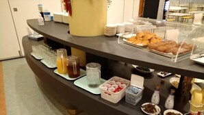 A buffet counter with various food items, beverages, and condiments. - Hotel Stay in Sanno Plaza (Tsuruoka)