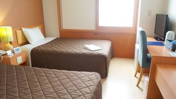 A hotel room with two beds, a desk, a chair, a television, and a window.