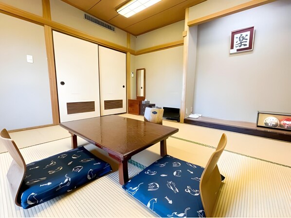 Ett traditionellt japanskt rum med tatamimattor på golvet, ett lågt träbord och shojiskärmar.