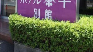 Un cartel con caracteres japoneses que indica un hotel o posada llamado "JCHA".