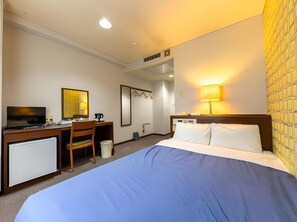 A hotel room with a bed, desk, chair, television, and a lamp. - Business Hotel Taihei Annex (Matsuyama)
