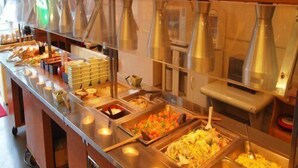 Un buffet proposant différents stands de nourriture, notamment un bar à salades et un espace dédié aux plats à base de riz.
