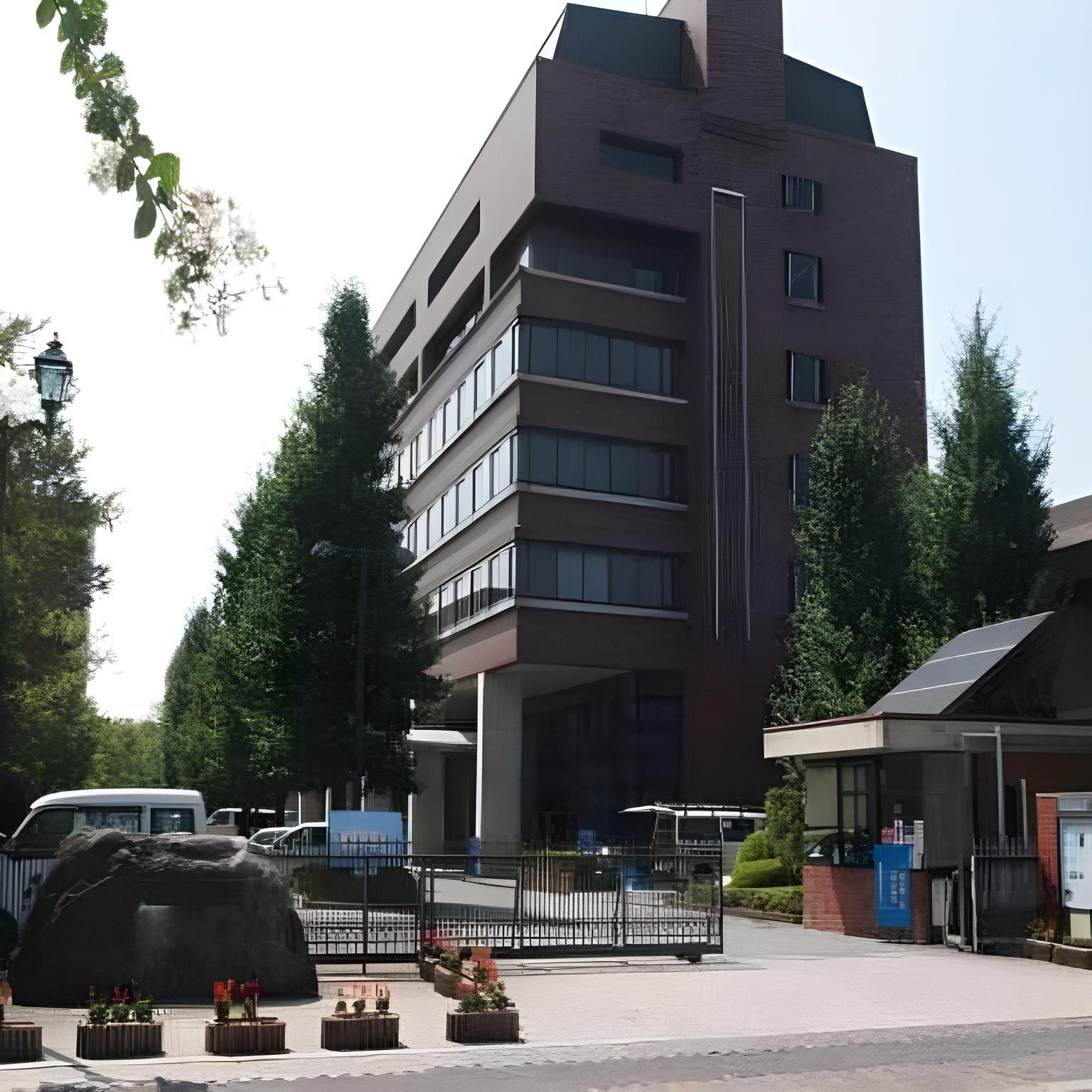 A multi-story building with a flat roof, large windows, and a central entrance.