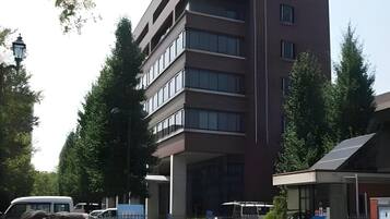 A multi-story building with a flat roof, large windows, and a central entrance.