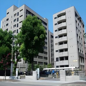 A modern building with multiple floors, large windows, and a tree in front. - Business Hotel Taihei Annex (Matsuyama)