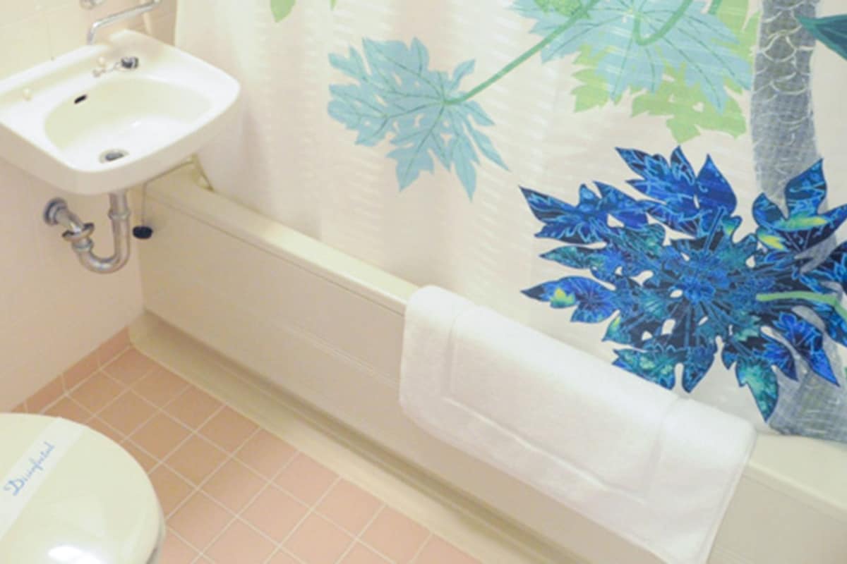 Une salle de bain avec des toilettes, un lavabo et une baignoire.