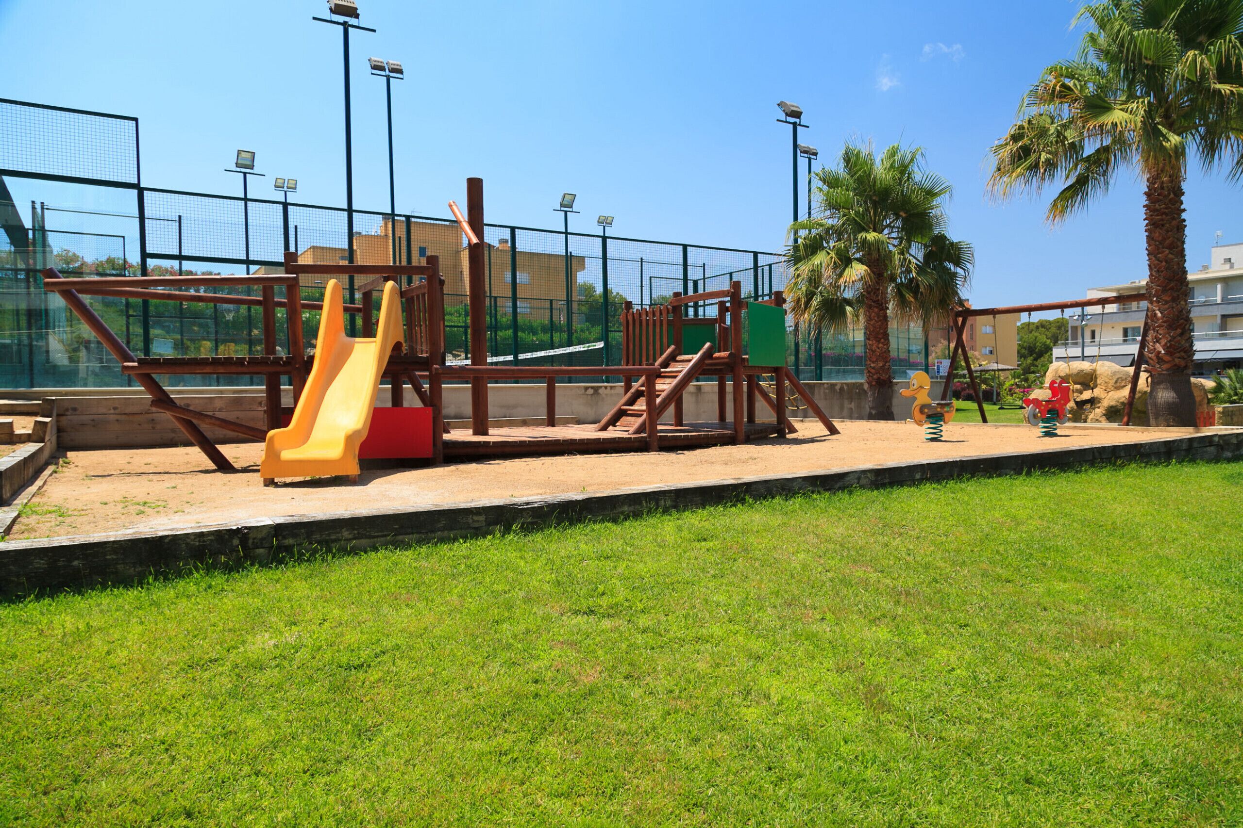 Un parque infantil con tobogán, columpios y estructuras para escalar.
