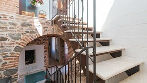 Una escalera de piedra con barandilla de metal que conduce a una plataforma.