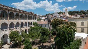 Un patio con una palmera, ventanas arqueadas y un edificio con torre.