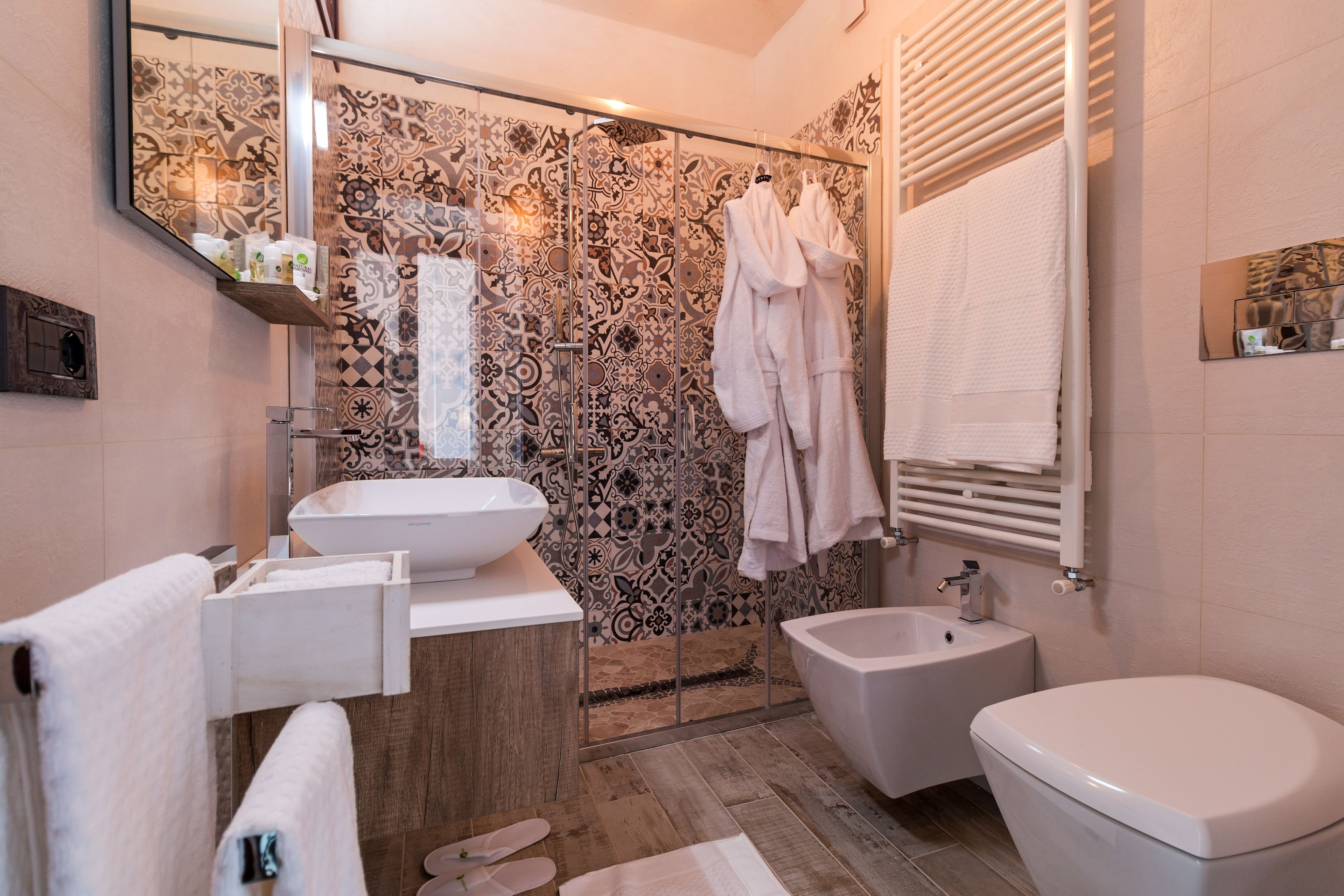 Un bagno moderno con uno specchio grande, un lavandino, un bidet e un water.