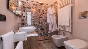 Un bagno moderno con uno specchio grande, un lavandino, un bidet e un water.