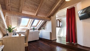 Una habitación moderna estilo loft con techo de madera, tragaluces, una cortina roja y un televisor de pantalla plana.
