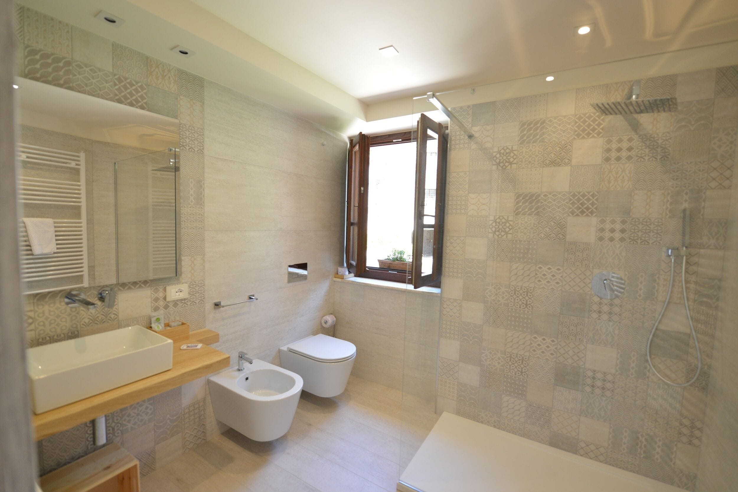 Une salle de bain moderne avec un grand lavabo, un bidet, des toilettes et une douche.