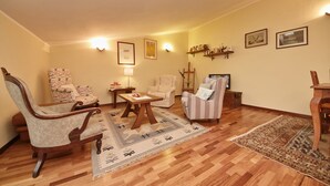 A living room with wooden flooring, a patterned rug, and several chairs. - L'Atelier (Desenzano del Garda)