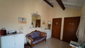 A room with a sofa, a cabinet, a mirror, and two doors. - Le Notti Mediterranee (Cervo)