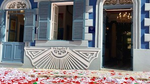 A building facade with blue shutters, a central emblem, and a chandelier visible through an arched doorway. - BOCO Boutique (Cospicua)