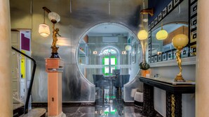 A modern lobby with a glass wall, a staircase with a quote, and elegant lighting fixtures. - BOCO Boutique (Cospicua)