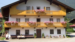 Ein zweistöckiges Gebäude mit Balkonen, einer Holzfassade und Blumenkästen.