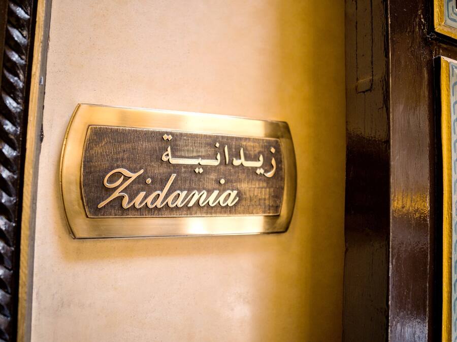 Una placa con el nombre 'Kidania' en árabe e inglés.