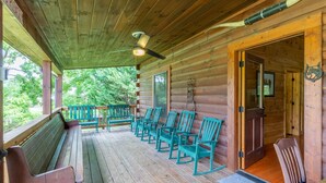 A wooden cabin with a porch, wooden benches, and rocking chairs. - Deep Creek Log Cabin- Motorcycle Friendly - Gas Fireplace - Covered Porch (Bryson City)