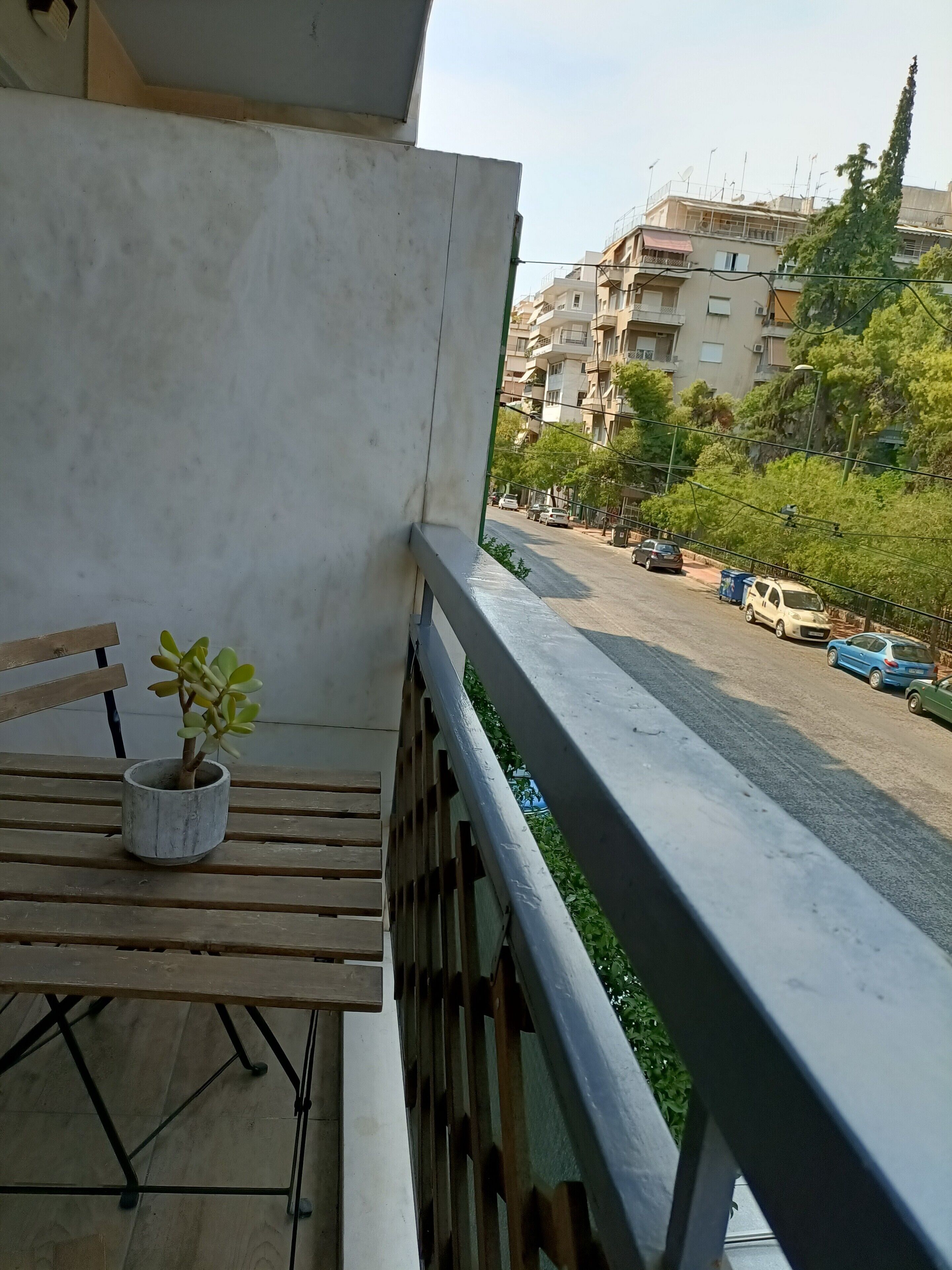 En balkon med en urtepotte og en træbænk.