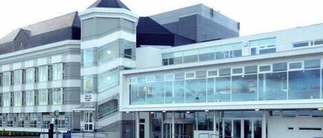 A modern building with a glass facade and a prominent entrance.